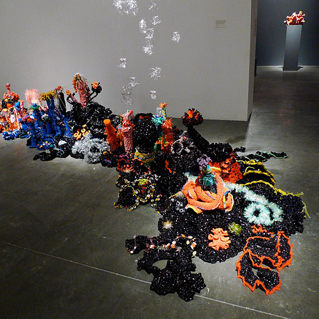 Crochet coral reef sculpture on the floor of the gallery.