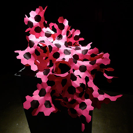 Pink paper model of hyperbolic space using hexagons.
