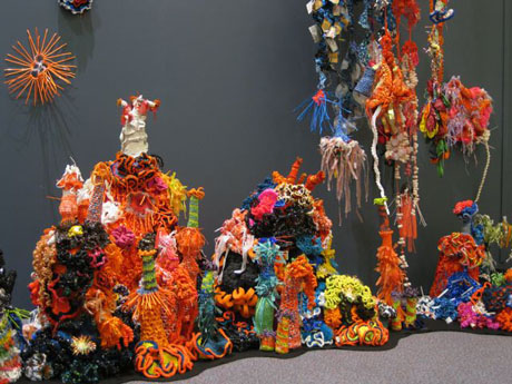 Detail of crochet coral reef sculptures installed on plinth in gallery.