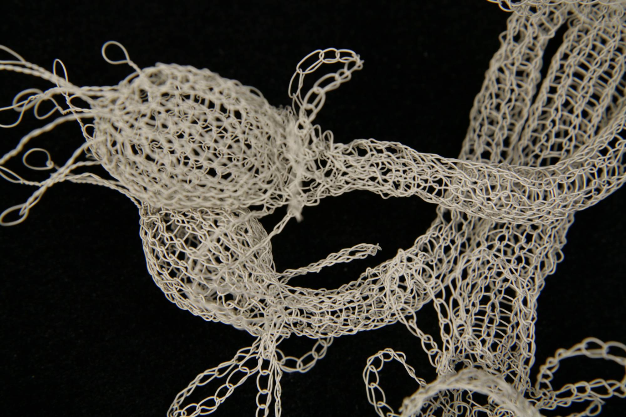 Delicate white objects knitted in wire, looks like a strange sea creature